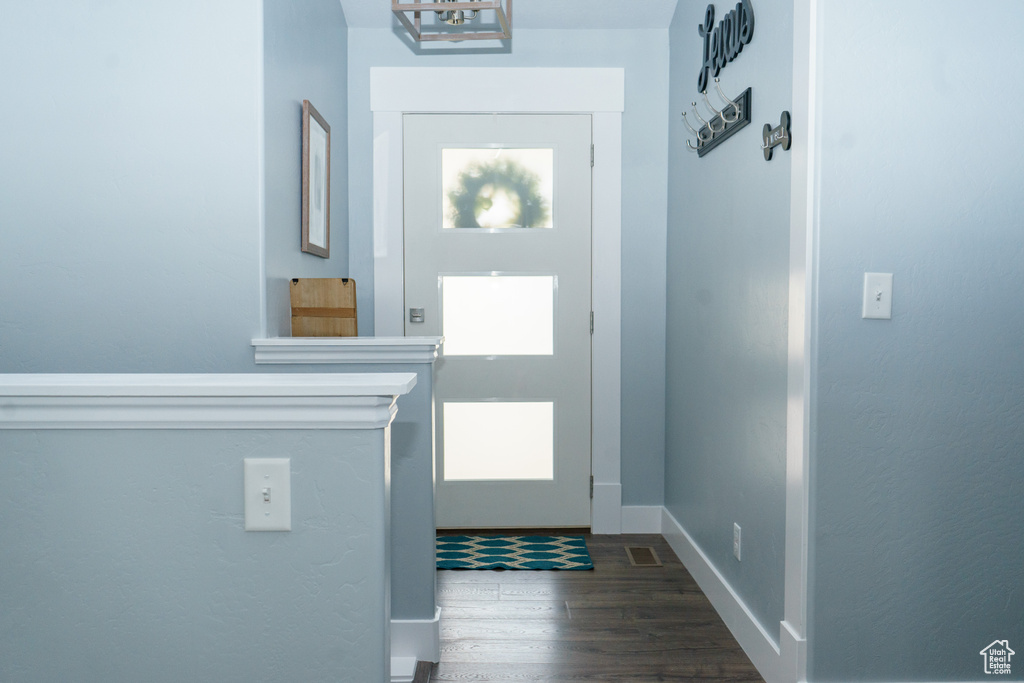 Doorway to outside with wood finished floors and baseboards