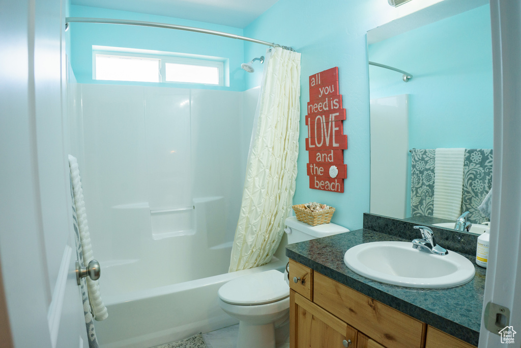 Bathroom featuring shower / tub combo, toilet, and vanity
