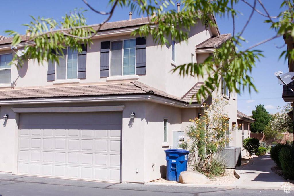 View of front facade featuring a garage and stucco siding