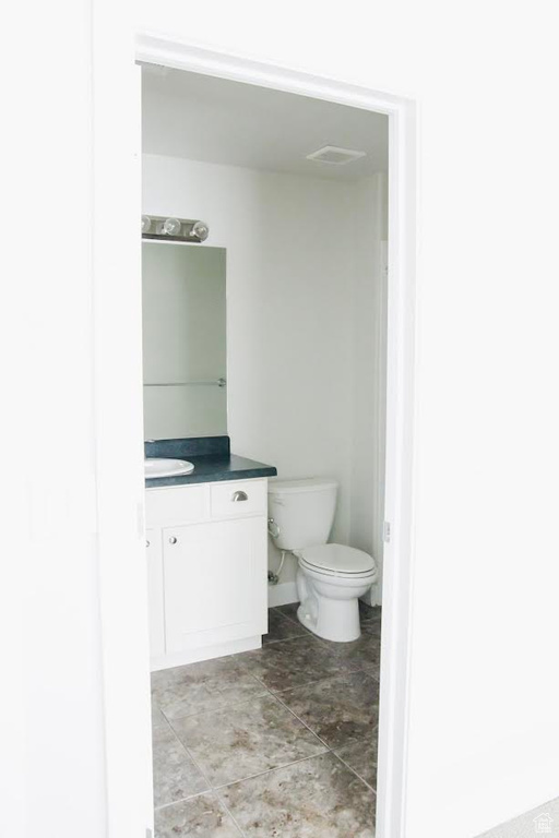 Half bathroom featuring vanity and toilet