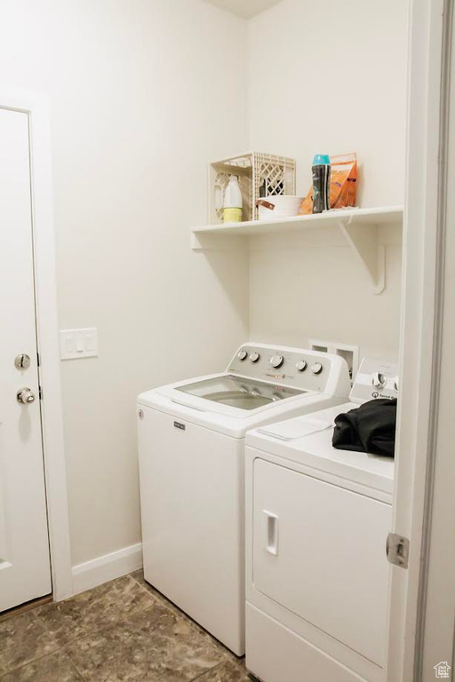 Washroom featuring washing machine and dryer and baseboards