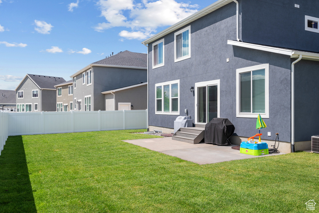 Back of house featuring a patio, stucco siding, cooling unit, and a residential view