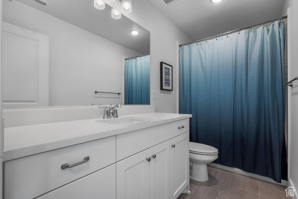 Bathroom featuring vanity, toilet, and recessed lighting