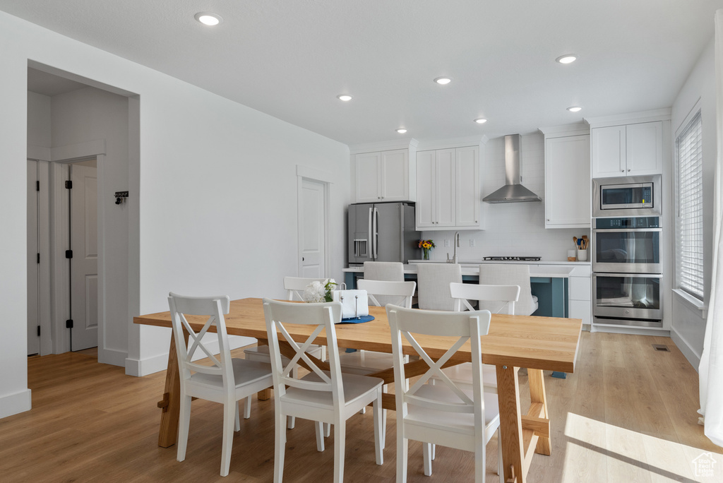 Dining space featuring light wood-style flooring, recessed lighting, and baseboards