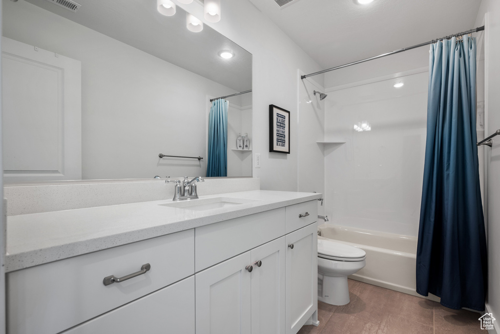 Full bath featuring toilet, vanity, shower / tub combo with curtain, and recessed lighting
