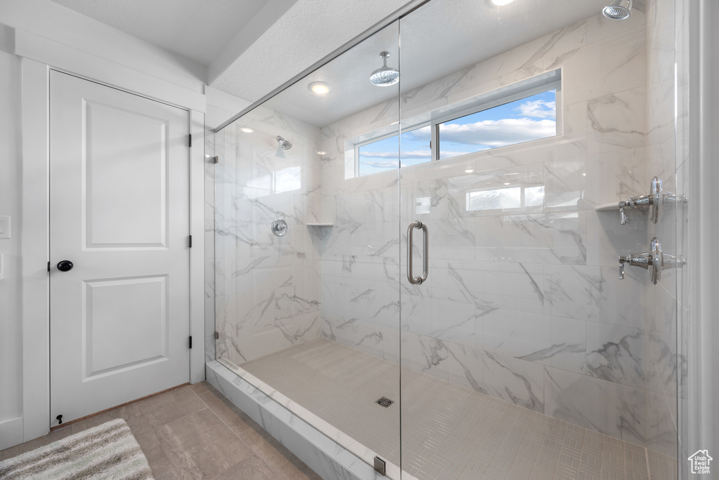 Full bath with a marble finish shower