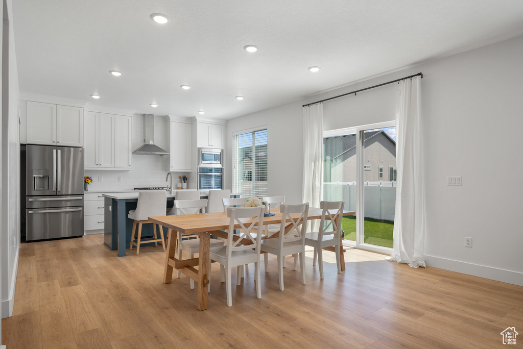 Dining area with light wood-style flooring, recessed lighting, and baseboards