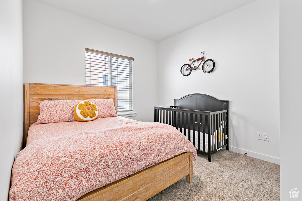 Bedroom featuring carpet and baseboards