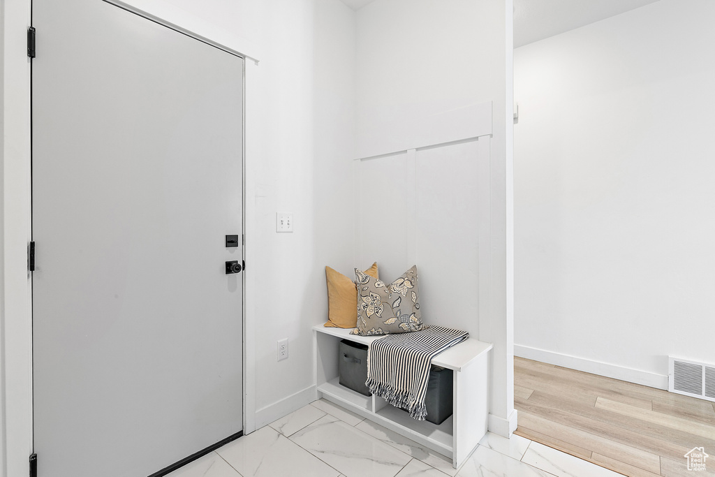 Mudroom featuring baseboards and light marble finish flooring
