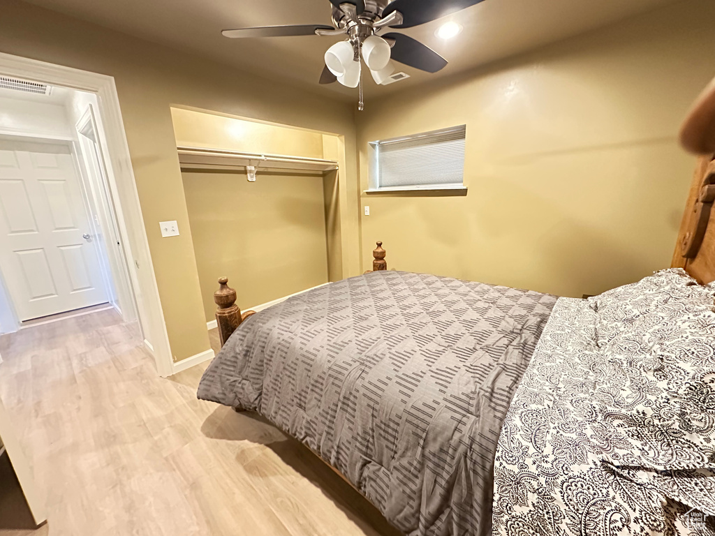 Bedroom with a closet, wood finished floors, and a ceiling fan