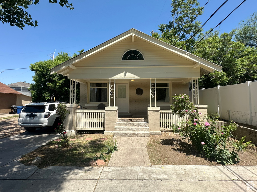 Bungalow-style home with covered porch and brick siding