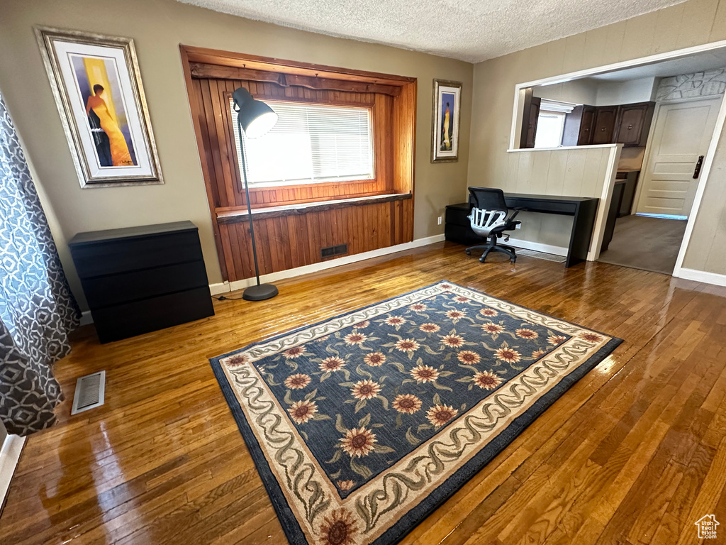 Office featuring dark wood finished floors, baseboards, and a textured ceiling