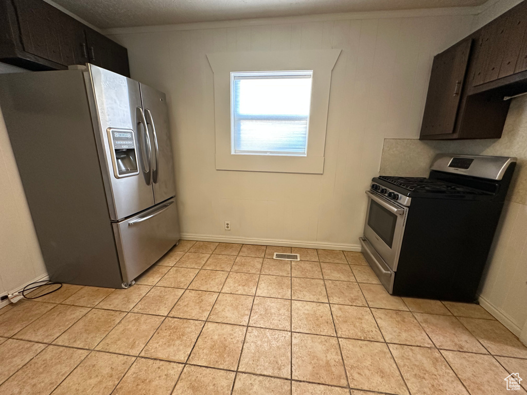 Kitchen featuring stainless steel appliances and light tile patterned flooring