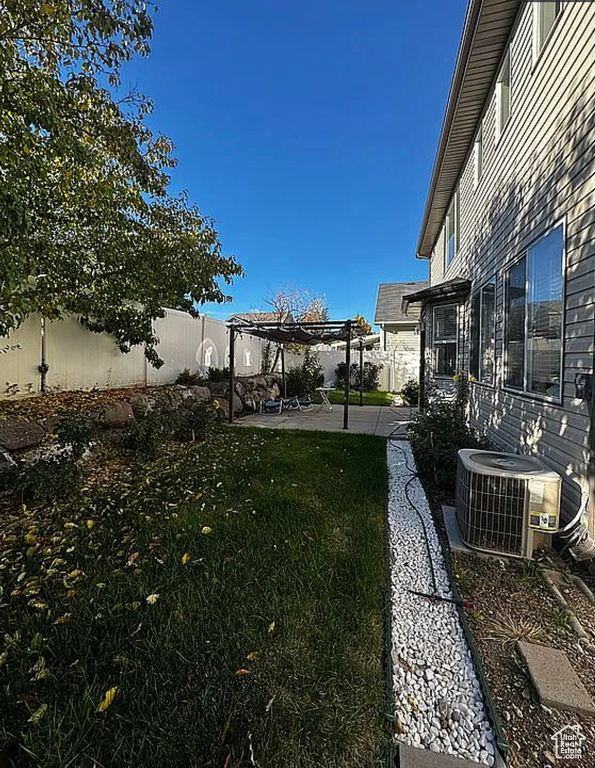 View of yard with cooling unit, a pergola, and a patio area