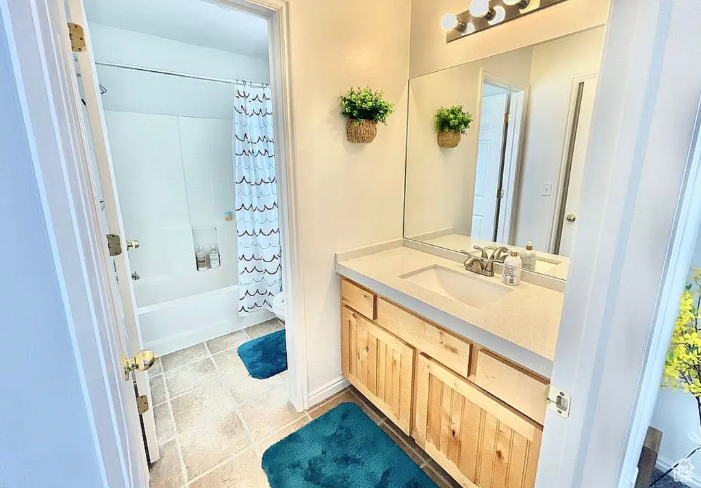 Full bath featuring vanity, shower / bath combination with curtain, and tile patterned floors