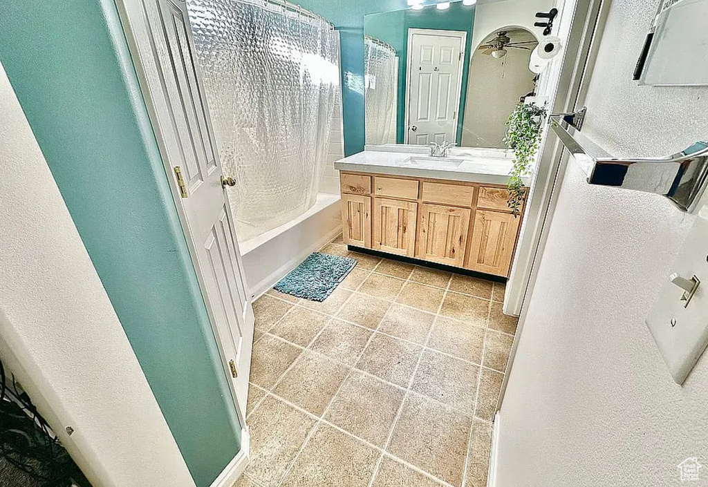 Full bathroom with vanity, shower / bath combination with curtain, and a textured wall