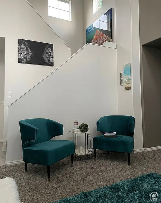 Living area featuring carpet flooring and baseboards