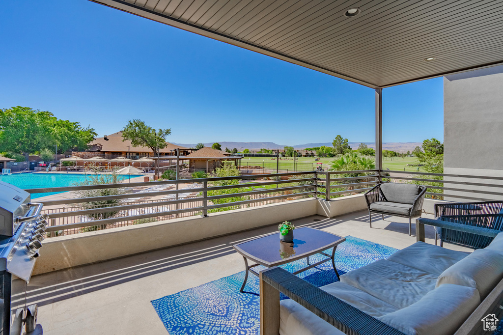 View of patio / terrace featuring an outdoor hangout area, a community pool, a mountain view, and a balcony