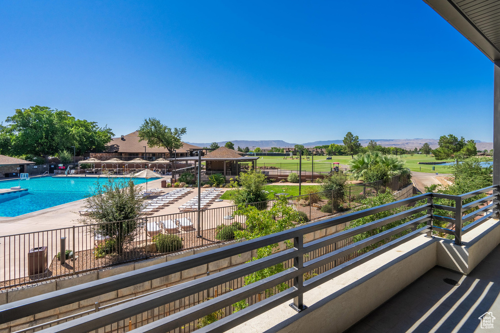 Balcony with view of pool area, a mountain view, and a patio area