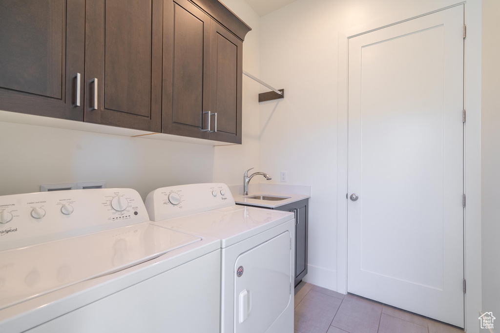 Laundry area featuring cabinet space, separate washer and dryer, and light tile patterned floors