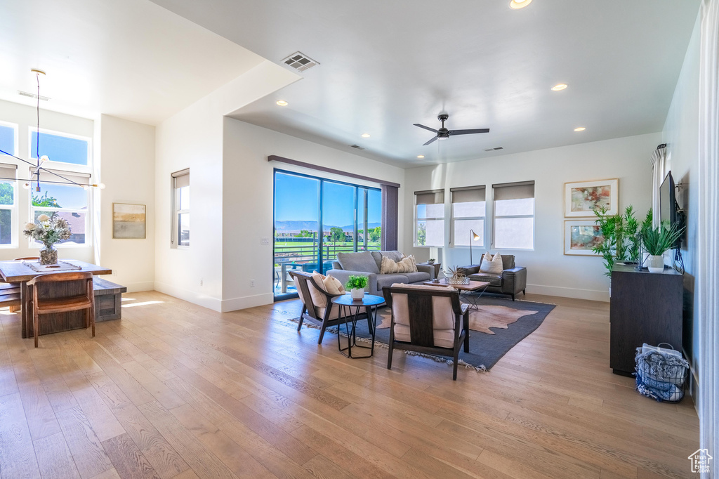 Living area with healthy amount of natural light, baseboards, light wood-style floors, and recessed lighting