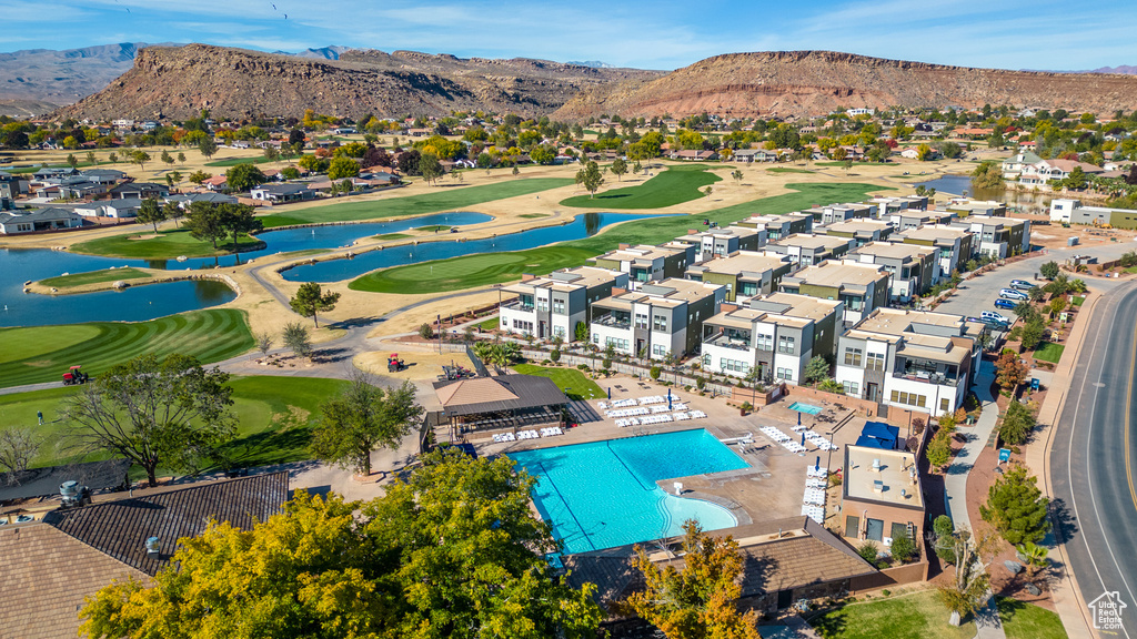 Aerial perspective of suburban area with a golf club, a water and mountain view, and a pool