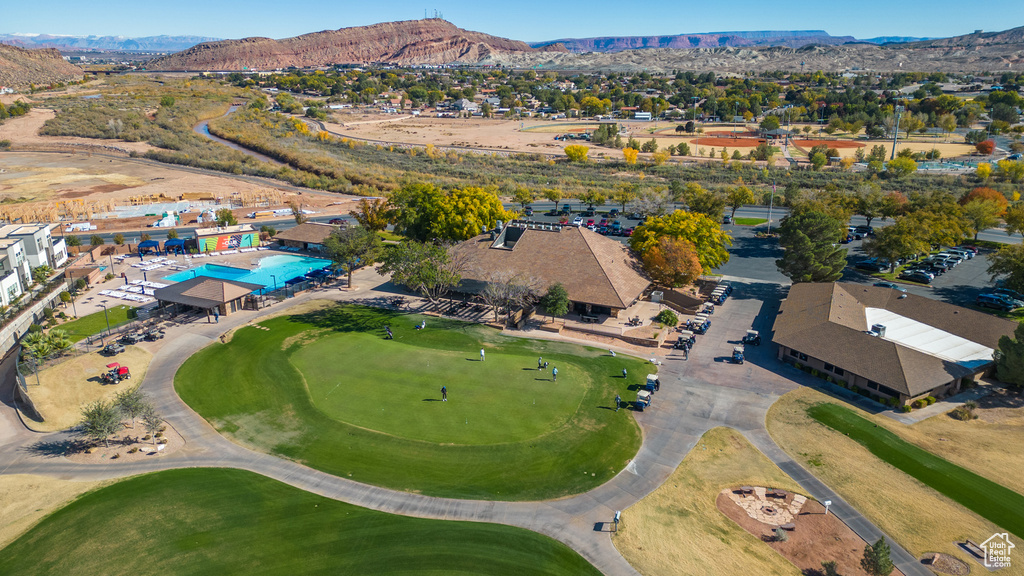 Aerial view of property and surrounding area featuring a mountain backdrop and a golf club