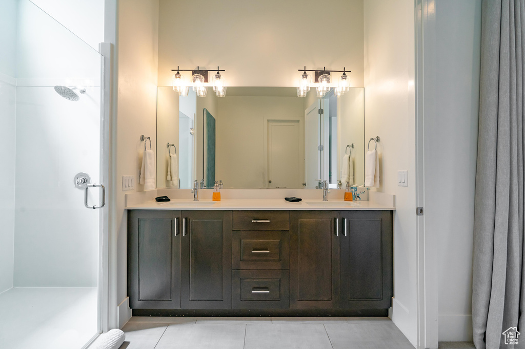 Bathroom featuring double vanity, a shower stall, and tile patterned floors
