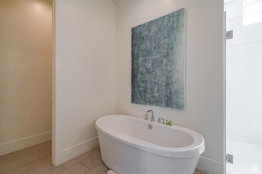 Full bath featuring a freestanding tub, baseboards, and tile patterned flooring
