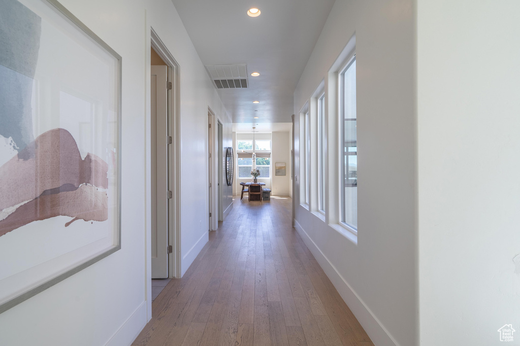 Hallway with wood-type flooring, baseboards, and recessed lighting
