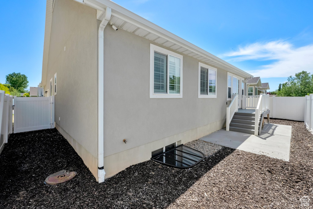 View of home\'s exterior featuring a fenced backyard, stucco siding, and a patio