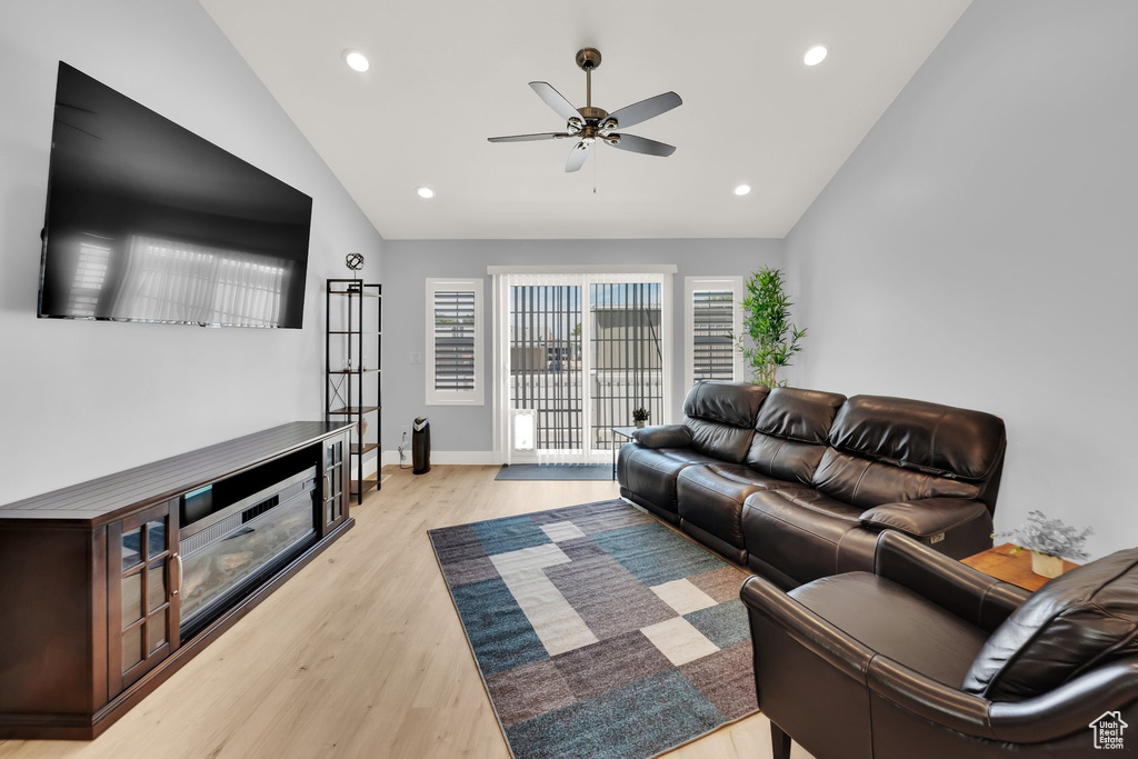 Living room featuring lofted ceiling, a ceiling fan, light wood-style floors, recessed lighting, and baseboards