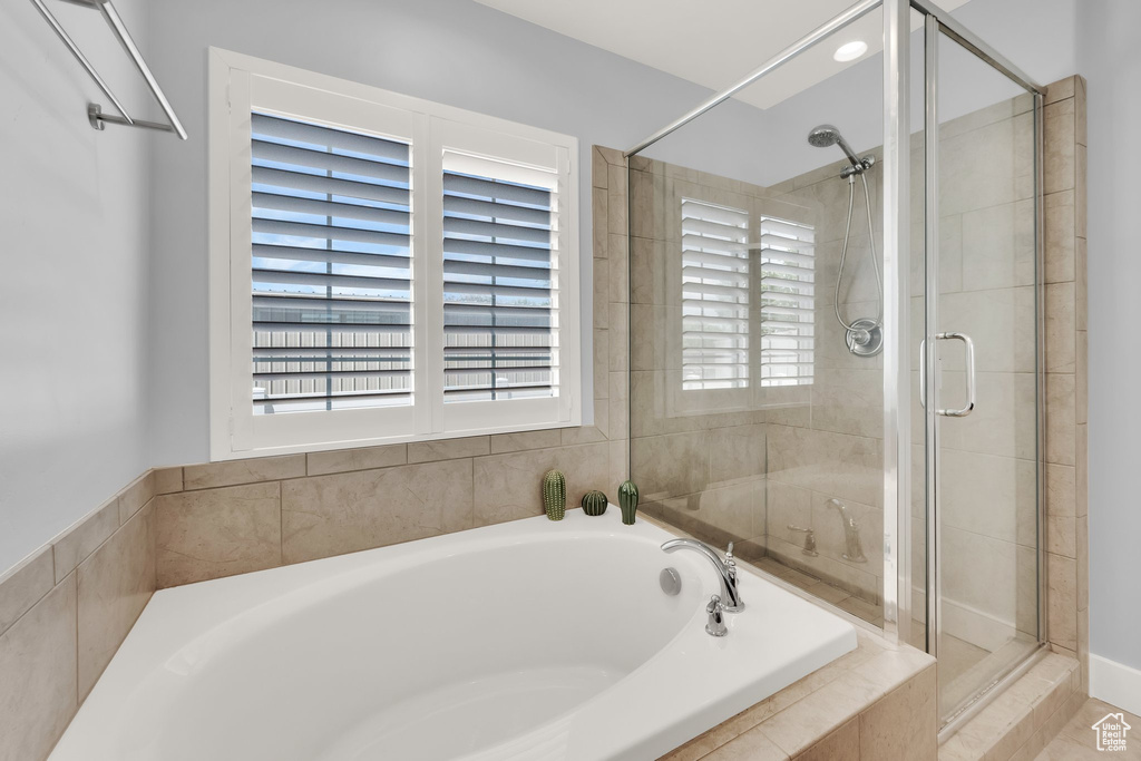 Full bath with a bath, a stall shower, and healthy amount of natural light