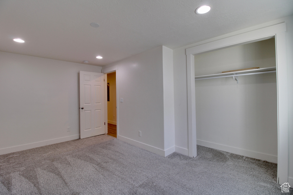 Unfurnished bedroom featuring recessed lighting, carpet, baseboards, and a closet