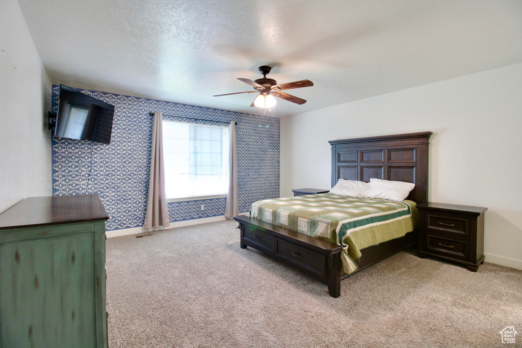 Bedroom featuring light carpet, baseboards, a ceiling fan, and wallpapered walls