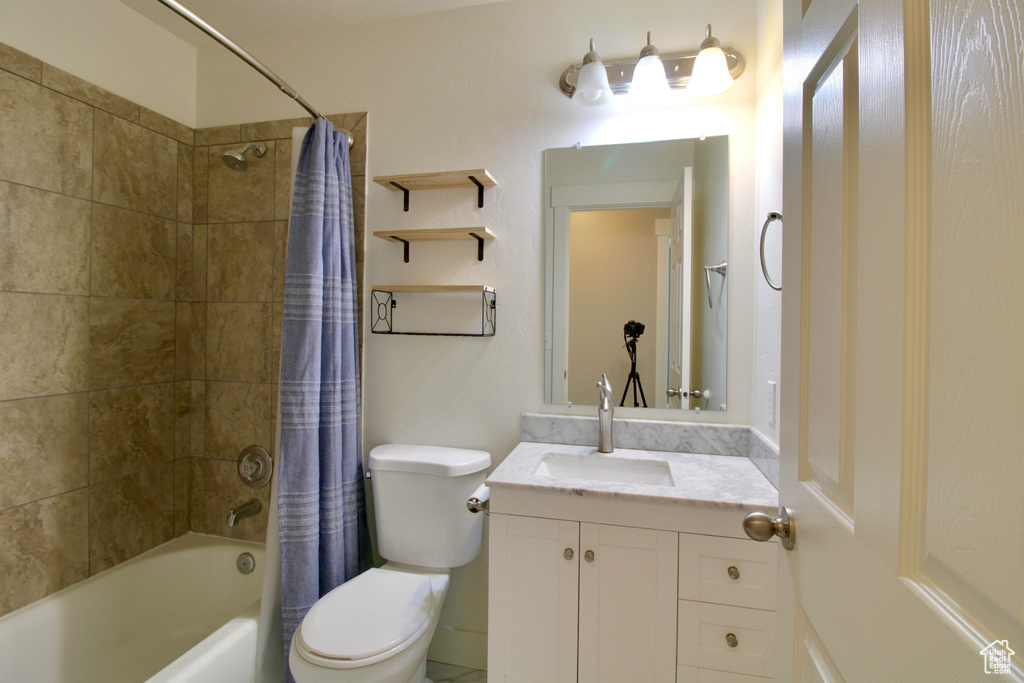 Full bath with vanity, toilet, and shower / bathtub combination with curtain