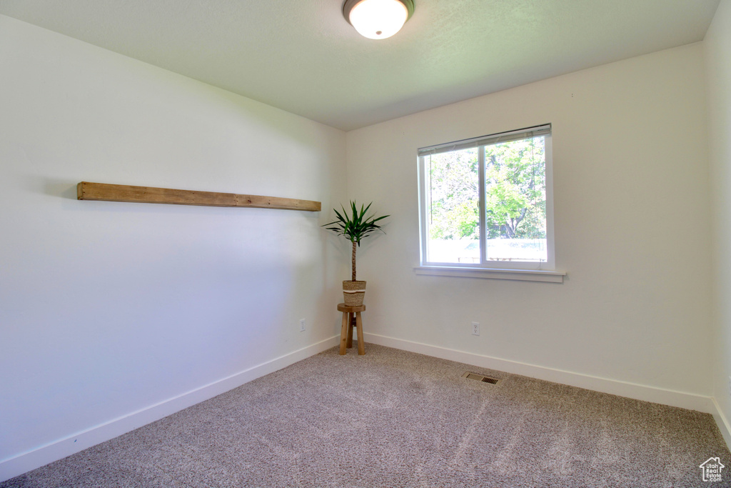 Carpeted empty room with baseboards