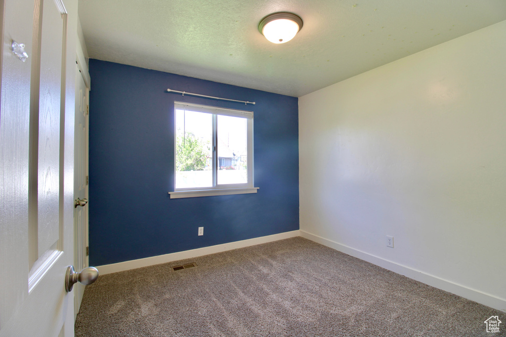 Empty room with carpet and baseboards
