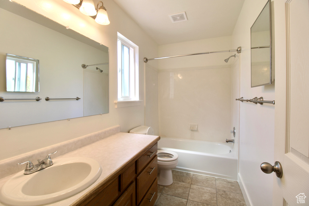 Bathroom with shower / bath combination, toilet, vanity, and tile patterned flooring