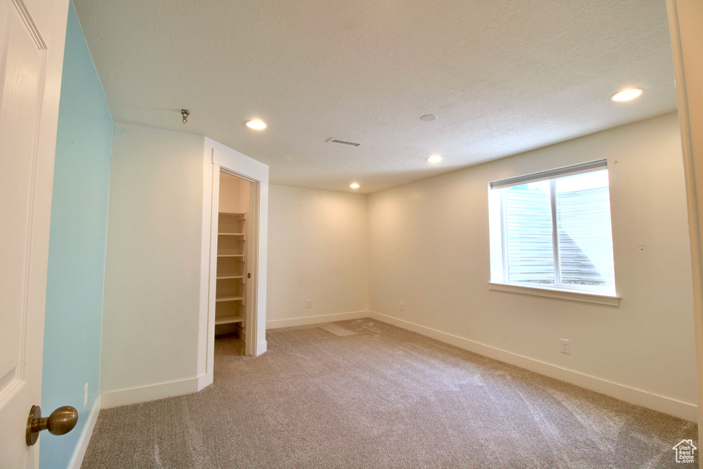 Spare room featuring recessed lighting, light colored carpet, and baseboards