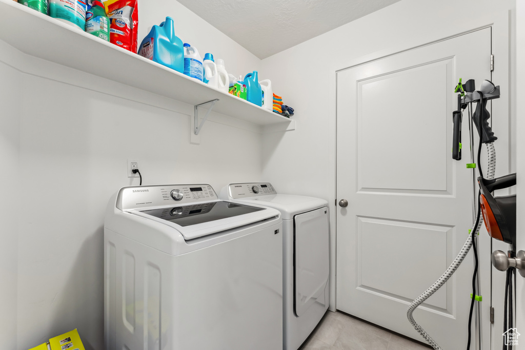 Laundry room featuring washer and dryer and light tile patterned floors
