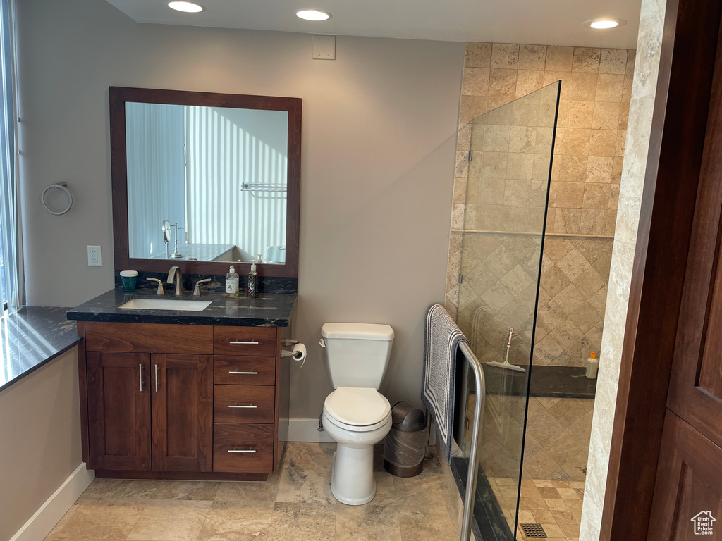 Bathroom featuring walk in shower, toilet, vanity, recessed lighting, and baseboards