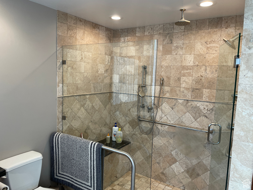 Bathroom with toilet, a stall shower, and recessed lighting