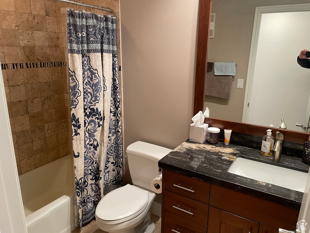Full bath with toilet, vanity, and shower / tub combo with curtain