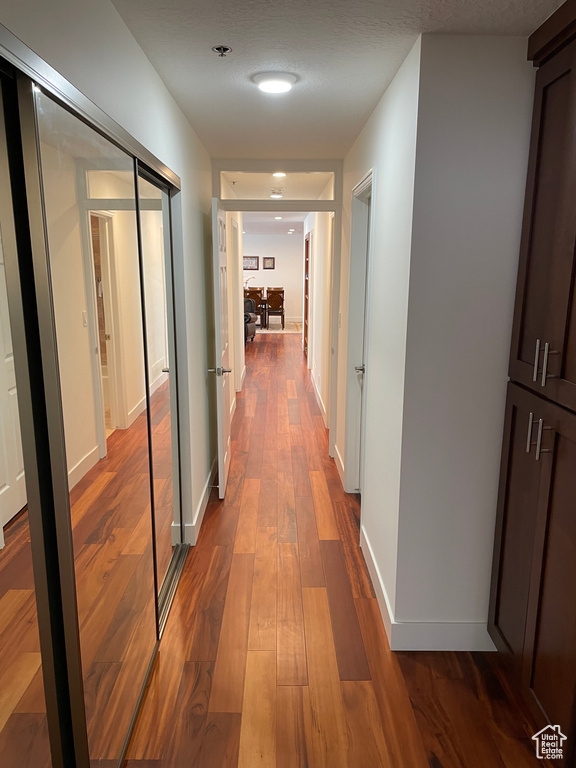 Hallway with dark wood-style flooring and baseboards