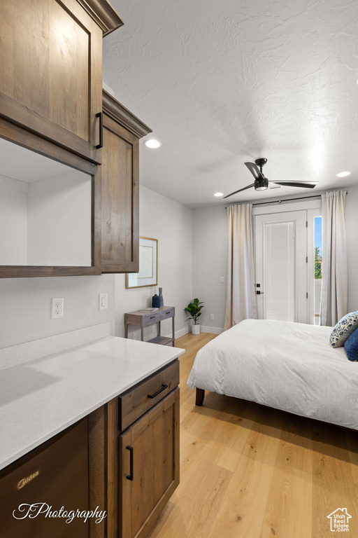 Bedroom with access to outside, light wood-type flooring, recessed lighting, baseboards, and a textured ceiling