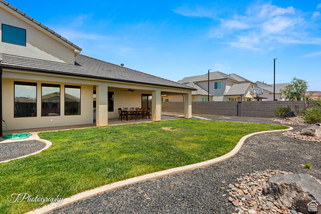 View of yard with a ceiling fan and a patio