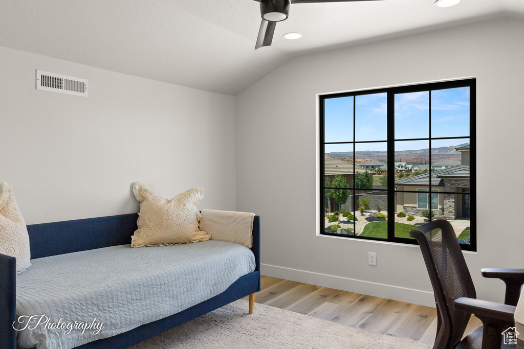 Bedroom featuring multiple windows, wood finished floors, vaulted ceiling, recessed lighting, and baseboards
