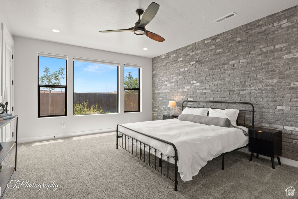 Carpeted bedroom with brick wall, a ceiling fan, baseboards, and recessed lighting