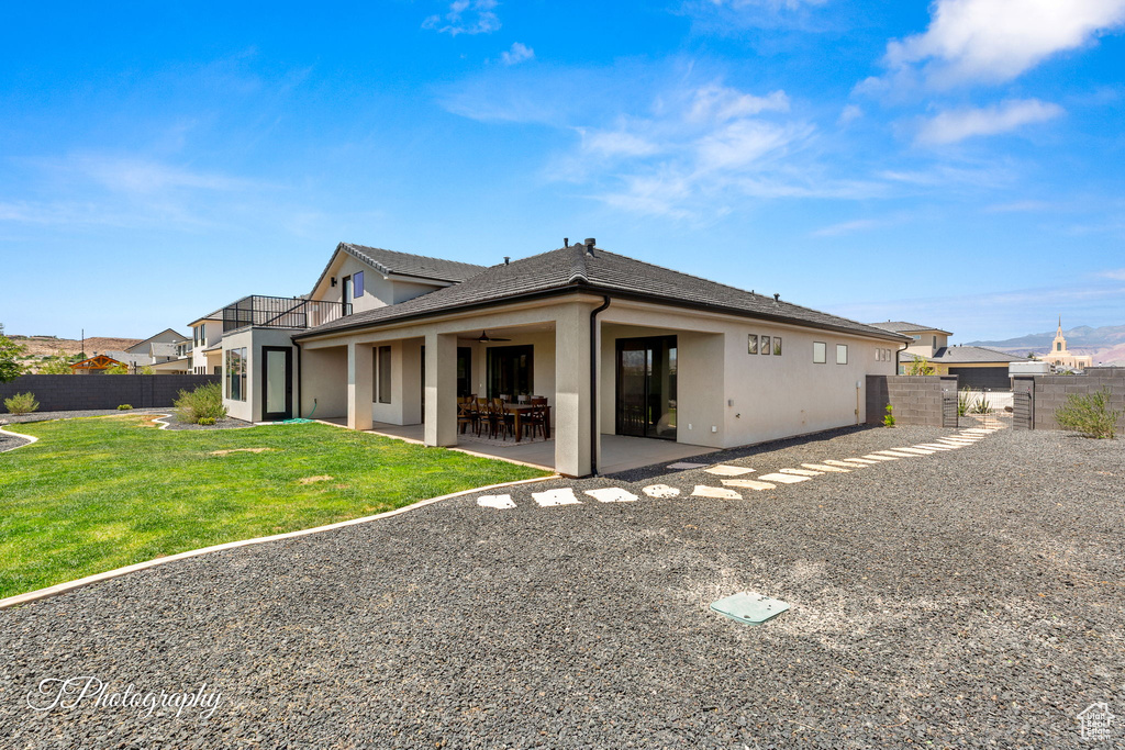Back of property with stucco siding, a patio area, and a ceiling fan